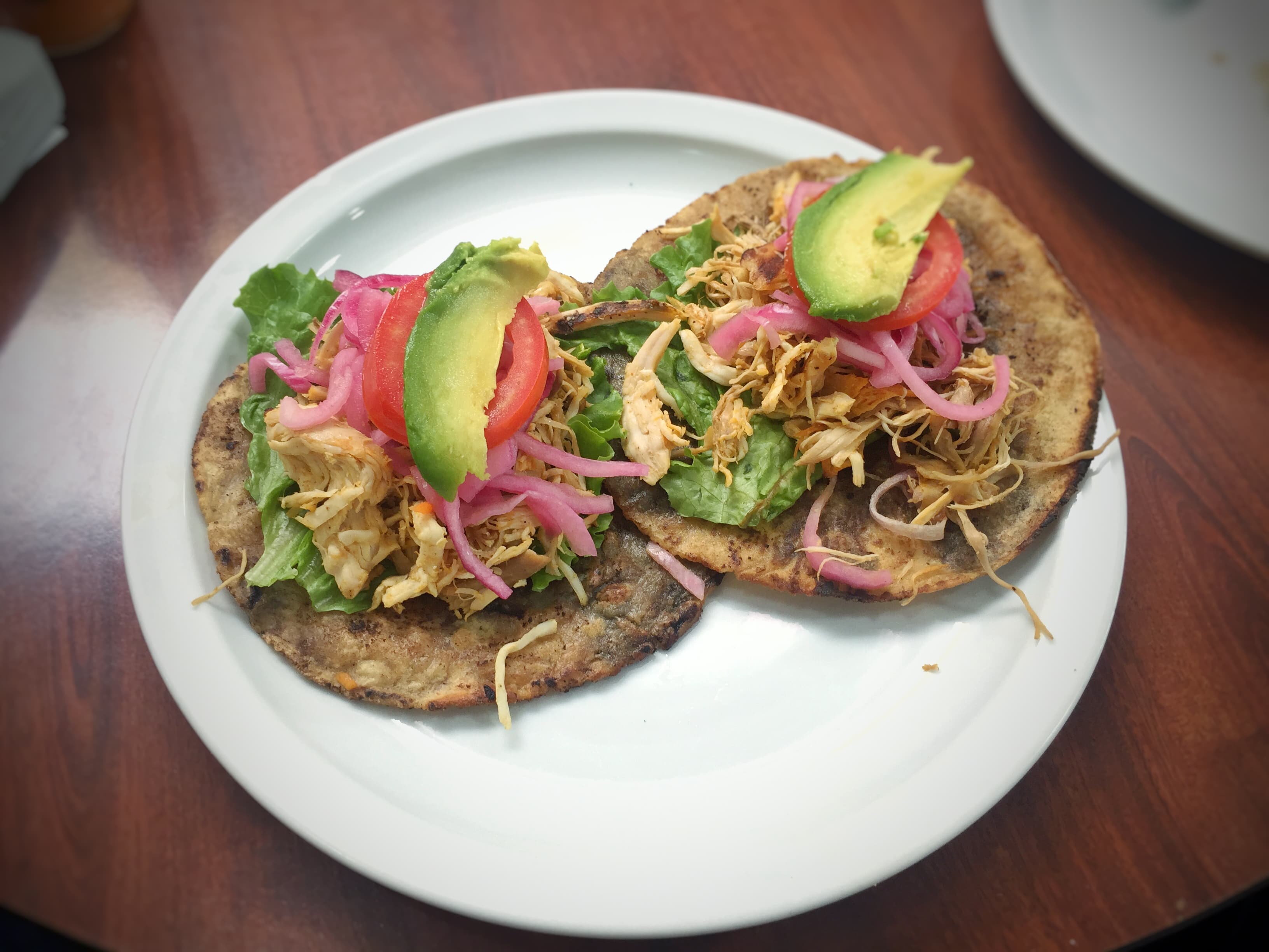 Panuchos topped with turkey, pickled onion and avocado